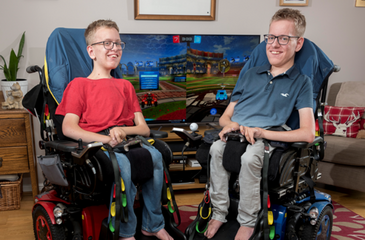 Image shows two teenagers who are twins and who have SMA.