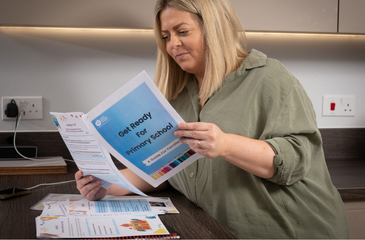 Image shows a mum looking at SMA UK's school information pack.