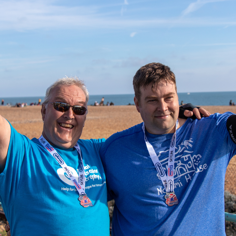 Two supporters celebrating completing the London to Brighton cycle on the beach