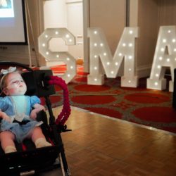 One year old girl with SMA with a party background