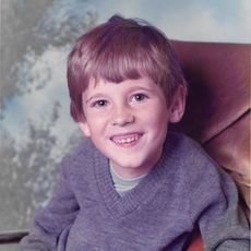 Boy in grey jumper smiling