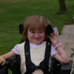 Young girl in powerchair in garden