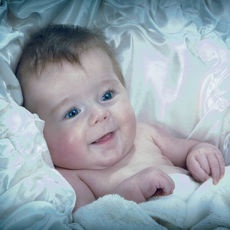 Young Baby in bed with white sheets