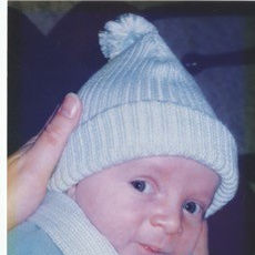 Baby in white and blue bobble hat