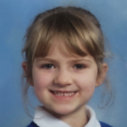 Image shows a young girl with fair hair in a blue school uniform with a white collar.