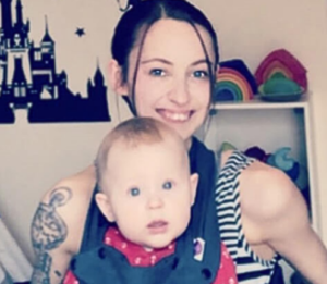 Image shows a mother who has SMA sitting in her wheelchair, with her baby boy sitting on her lap.