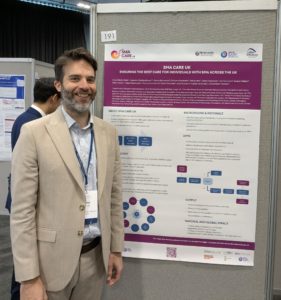 Dr. James Lilleker, Consultant Neurologist and Honorary Senior Lecturer at the Manchester Centre for Clinical Neuroscience in front of the SMA Care UK poster at the ABN conference 2025.