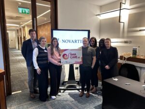 Image shows novarits employees holding placard that says SMA Care UK