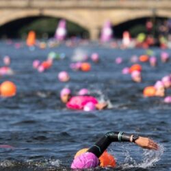 image shows swimmers in a river