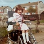 Clare as a child in old style wheelchair
