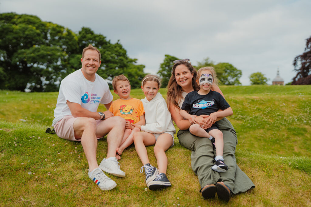 image shows family sitting on a hill