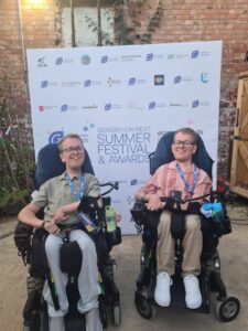 Sam & Alex Bolton with background of Generation Next Summer Festival & Awards